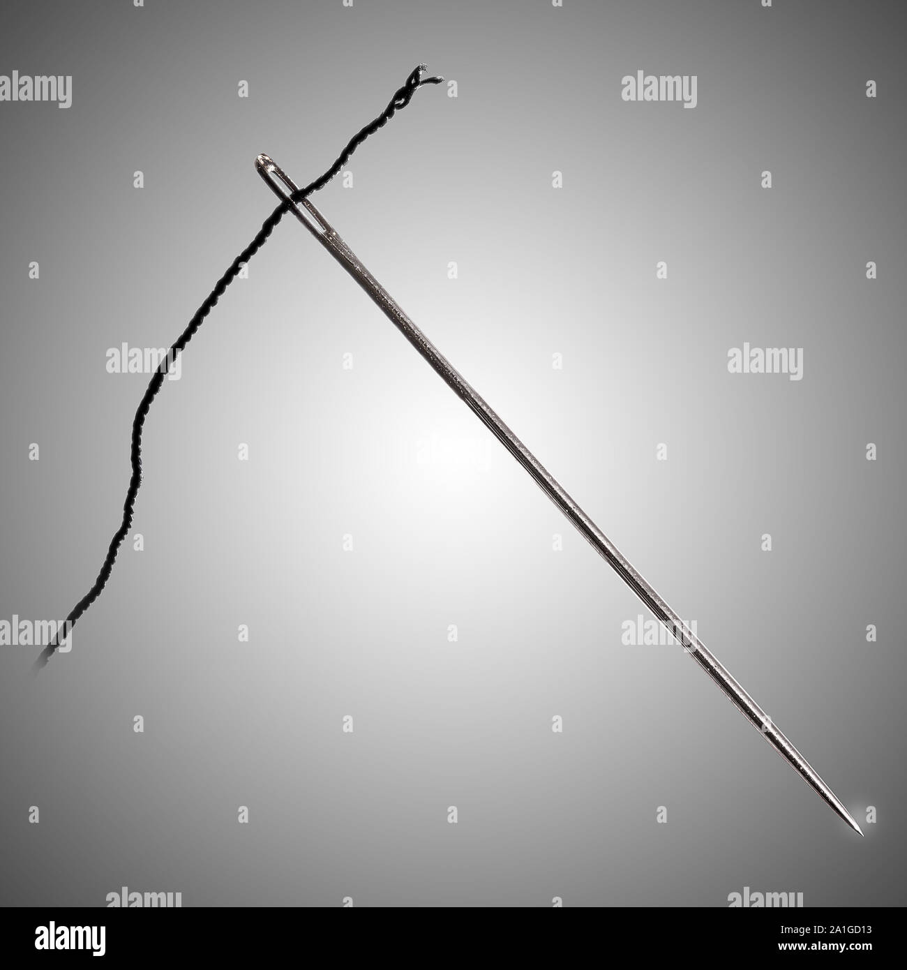 Studio shot of a sewing needle, isolated, closeup macro, with black thread Stock Photo