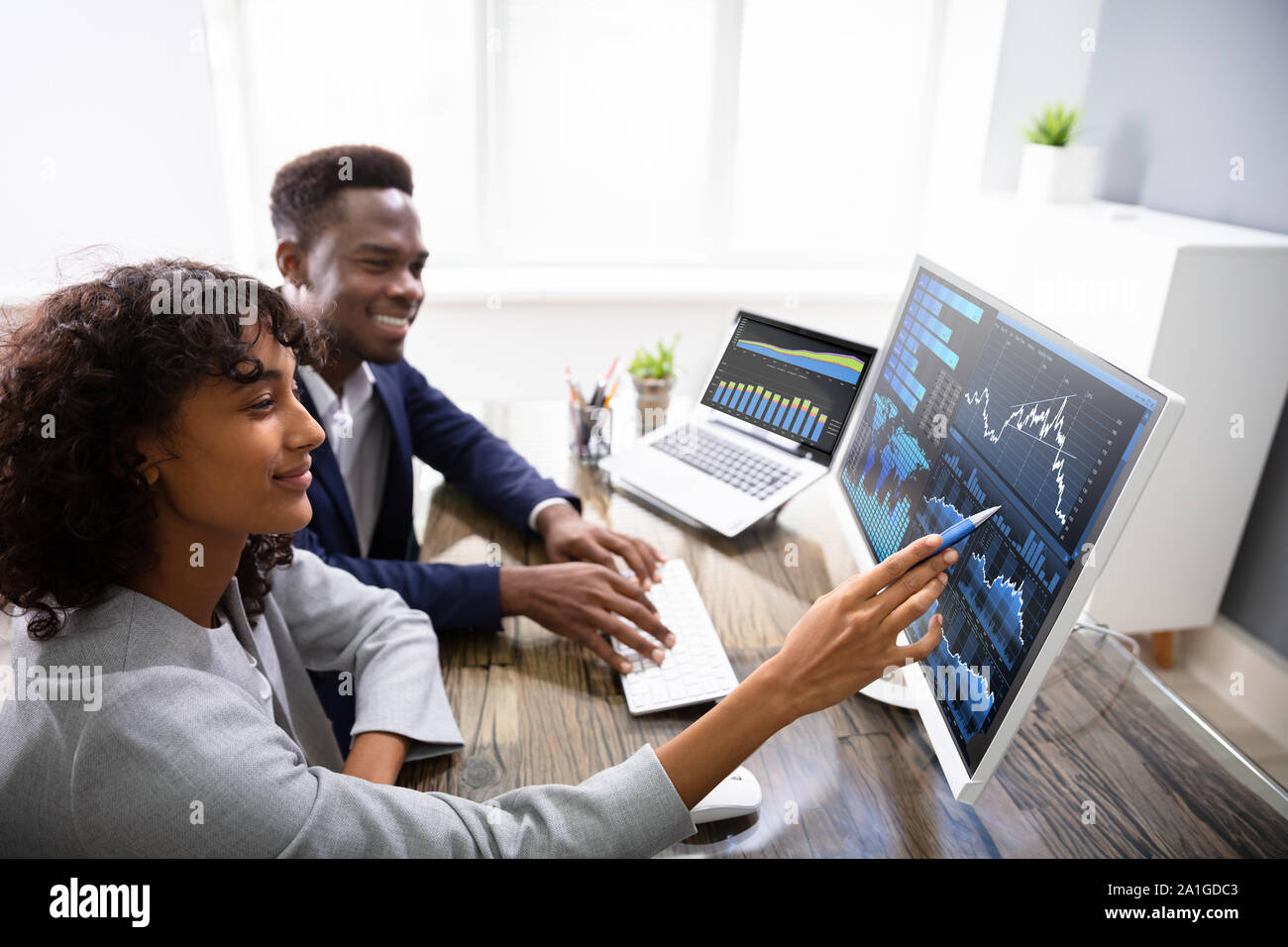 Stock Market Broker Analyzing Graphs On Computer In Office Stock Photo