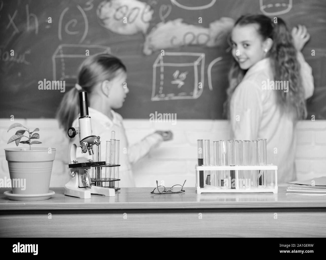 Smart cuties. School children in science classroom. Microscope and