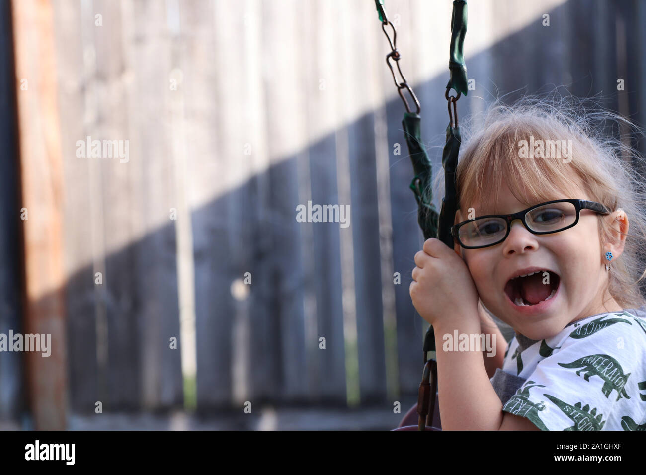 Child laughing on a swing Stock Photo