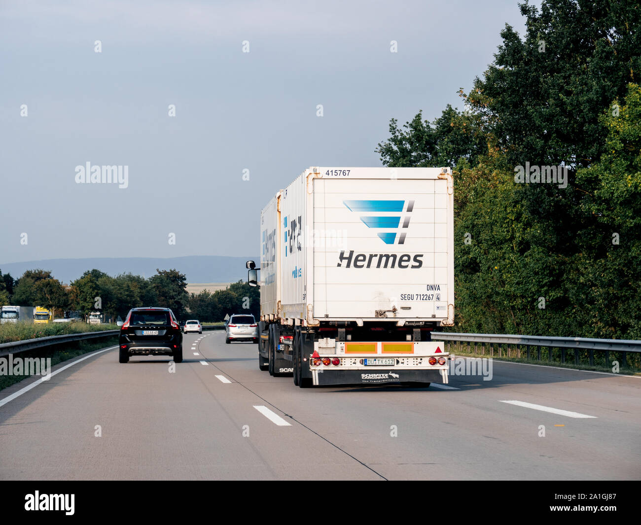 Germany - Aug 29, 2019: Rear view of cargo truck with hermes delivery parcel sign on the back - driving fast on German autobahn Stock Photo