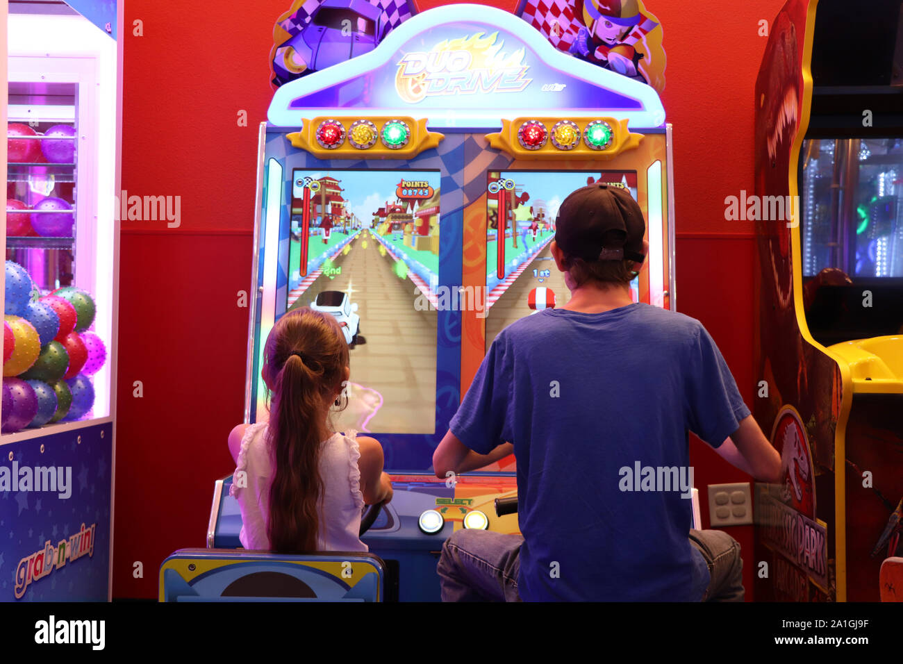 Two playing a video game at the arcade Stock Photo