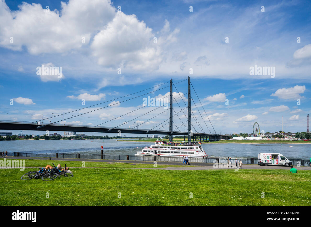 excursion boat  MS Stadt Düsseldorf passes the Apollo Wiese meadows on the River Rhine at Düsseldorf, against the backdrop of the Rheinknie cable-stay Stock Photo