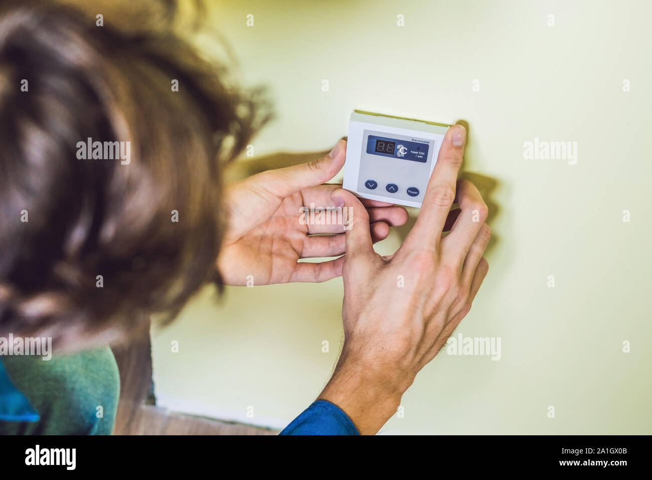 electrician installing an electrical thermostat in a new house Stock