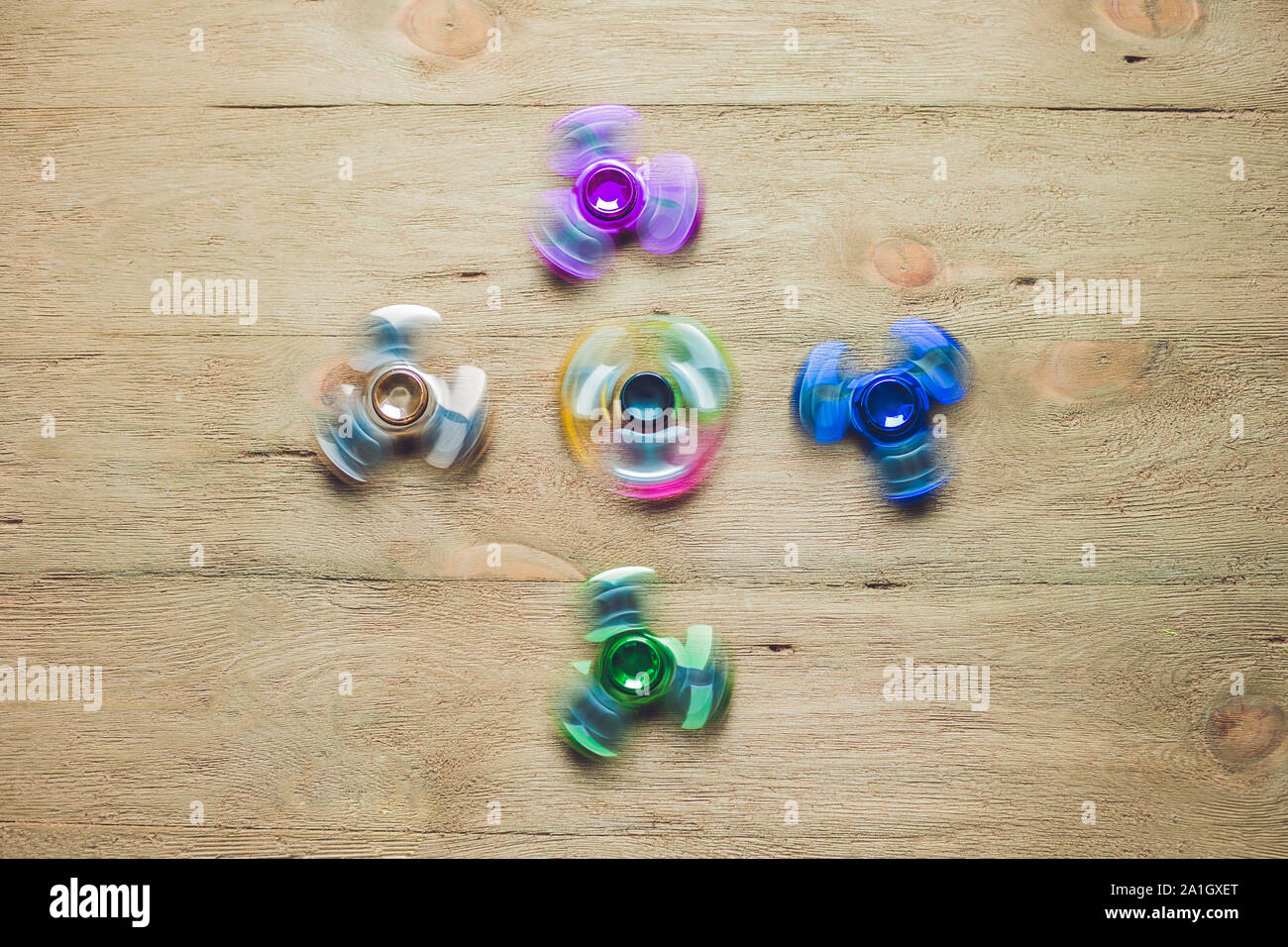 Colored fidget spinners stress relieving toy on wooden background Stock ...