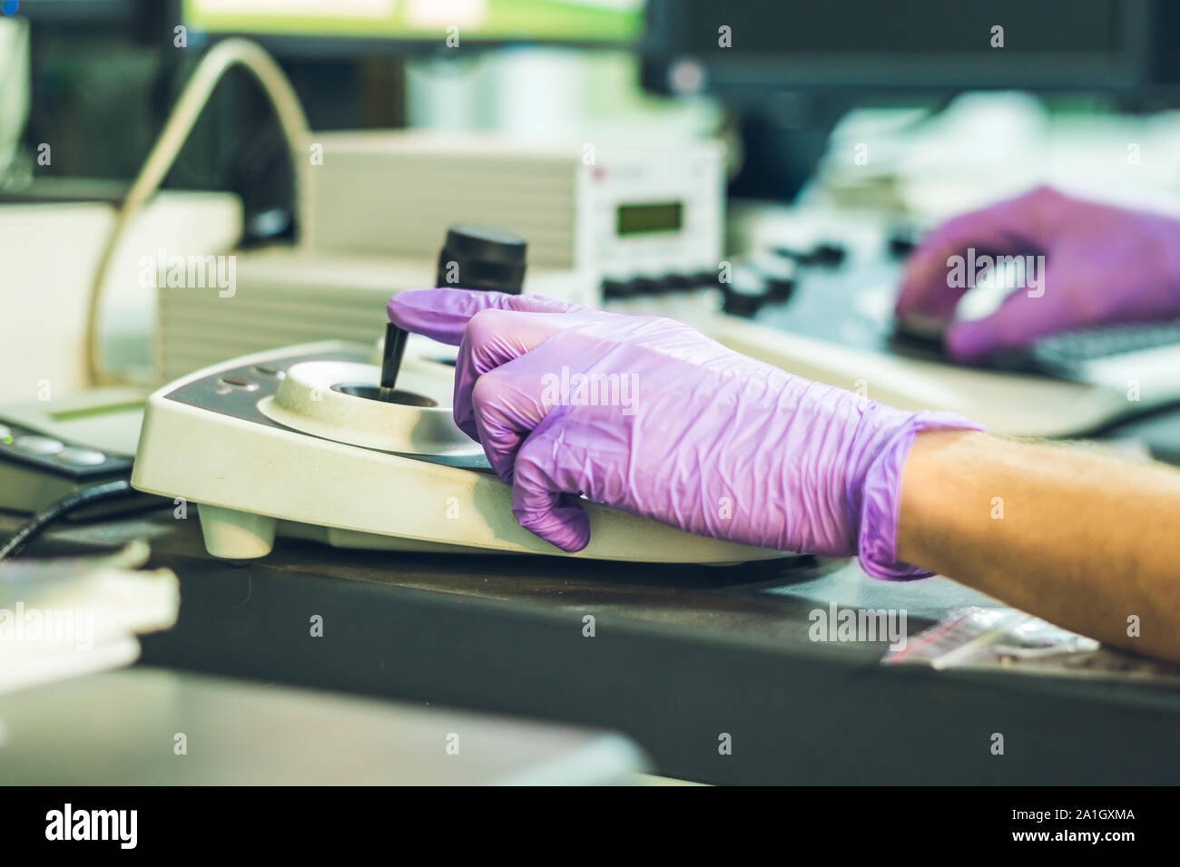 Hands of a scientist on a ontrol panel of an electron microscope. Stock Photo