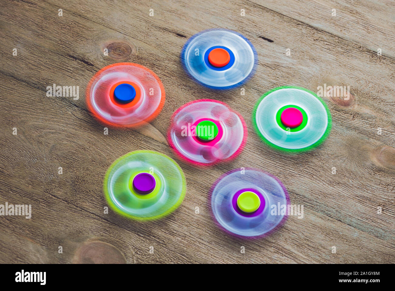 Colored fidget spinners stress relieving toy on wooden background Stock ...