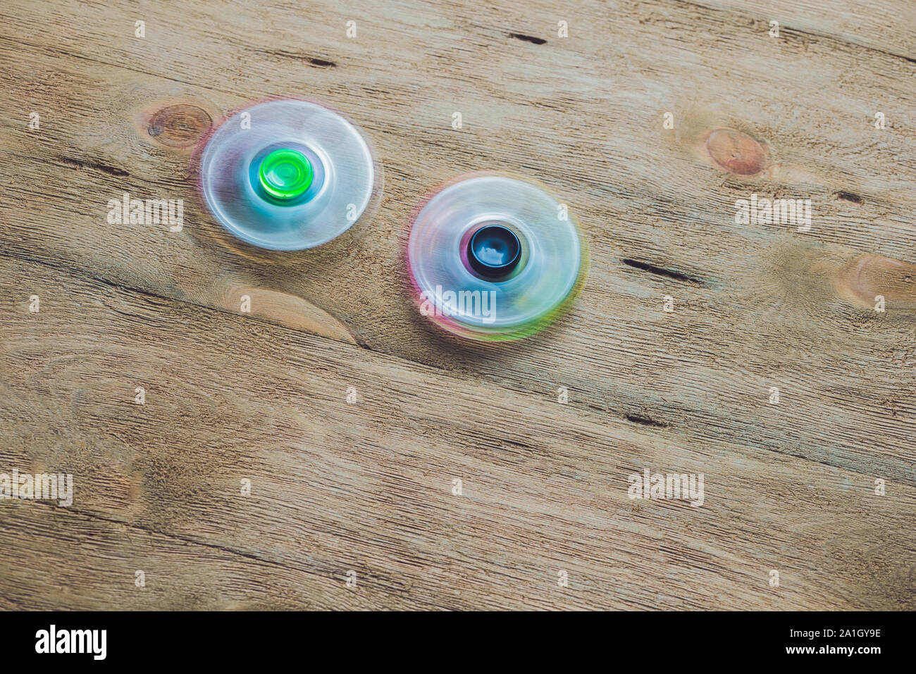 Colored fidget spinners stress relieving toy on wooden background Stock ...