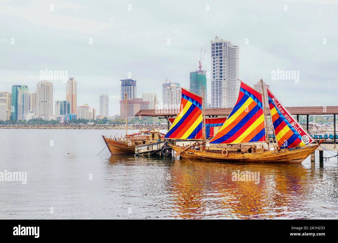Example of a traditional Filipino wooden sailing vessel called a balangay. The 'Sultan Sin Sulu' is a replica docked in Manila Bay. Stock Photo