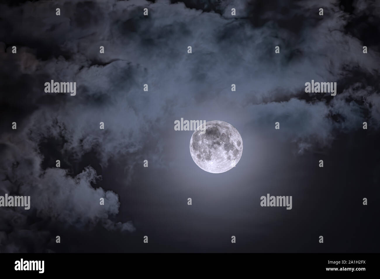 Night sky and a full moon in the clouds. Full moon against the dark ...