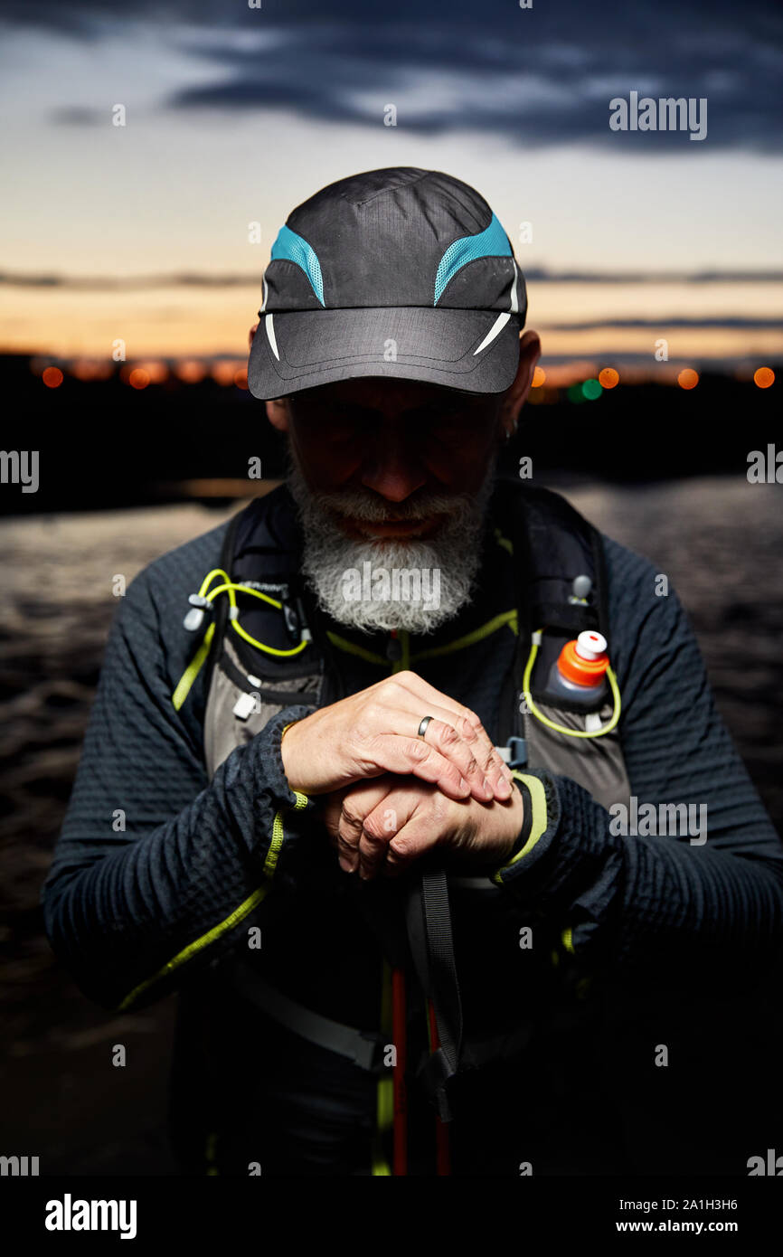 Portrait of athlete with grey beard and shadow on his eyes at night city background Stock Photo
