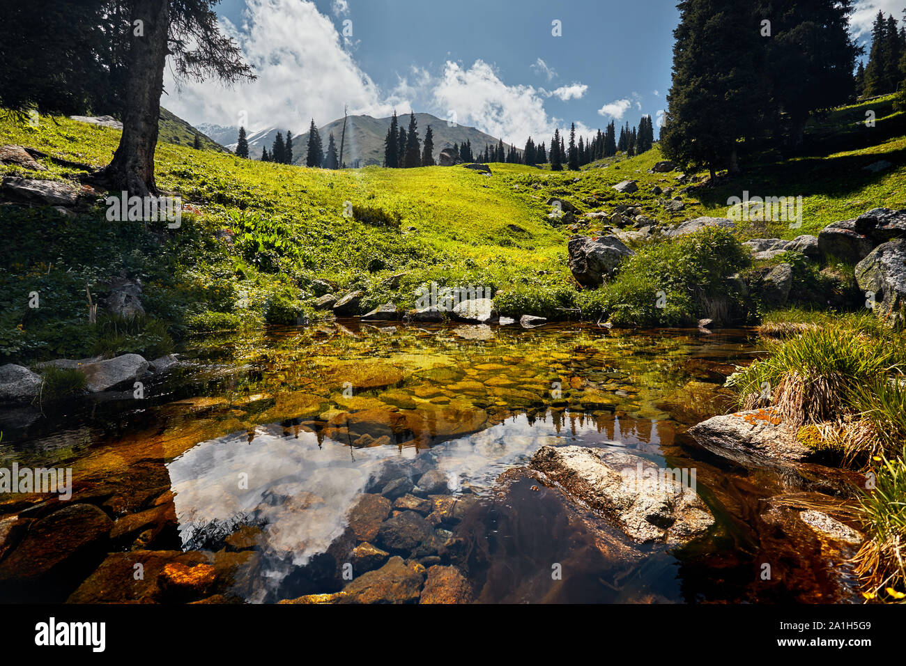 Mountains reflection in the clear lake at sunny day Stock Photo
