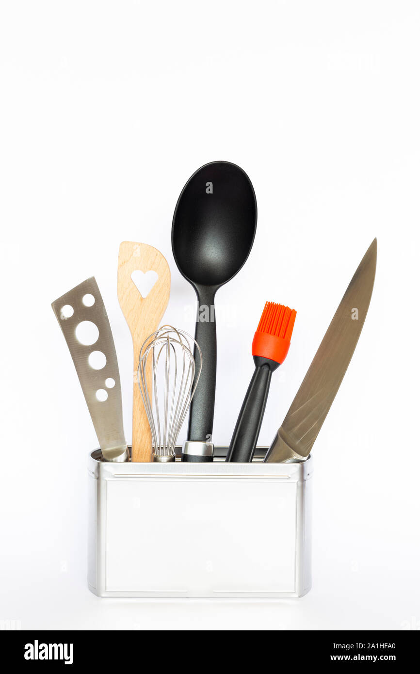 Assortment of kitchenware and cooking tools in a square silver colored metal box with copy space on white background Stock Photo