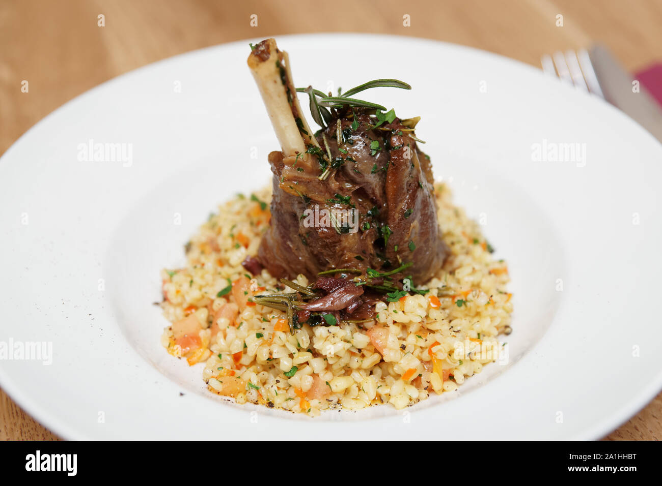 Braised lamb shank with herbs and bulgur cereal Stock Photo