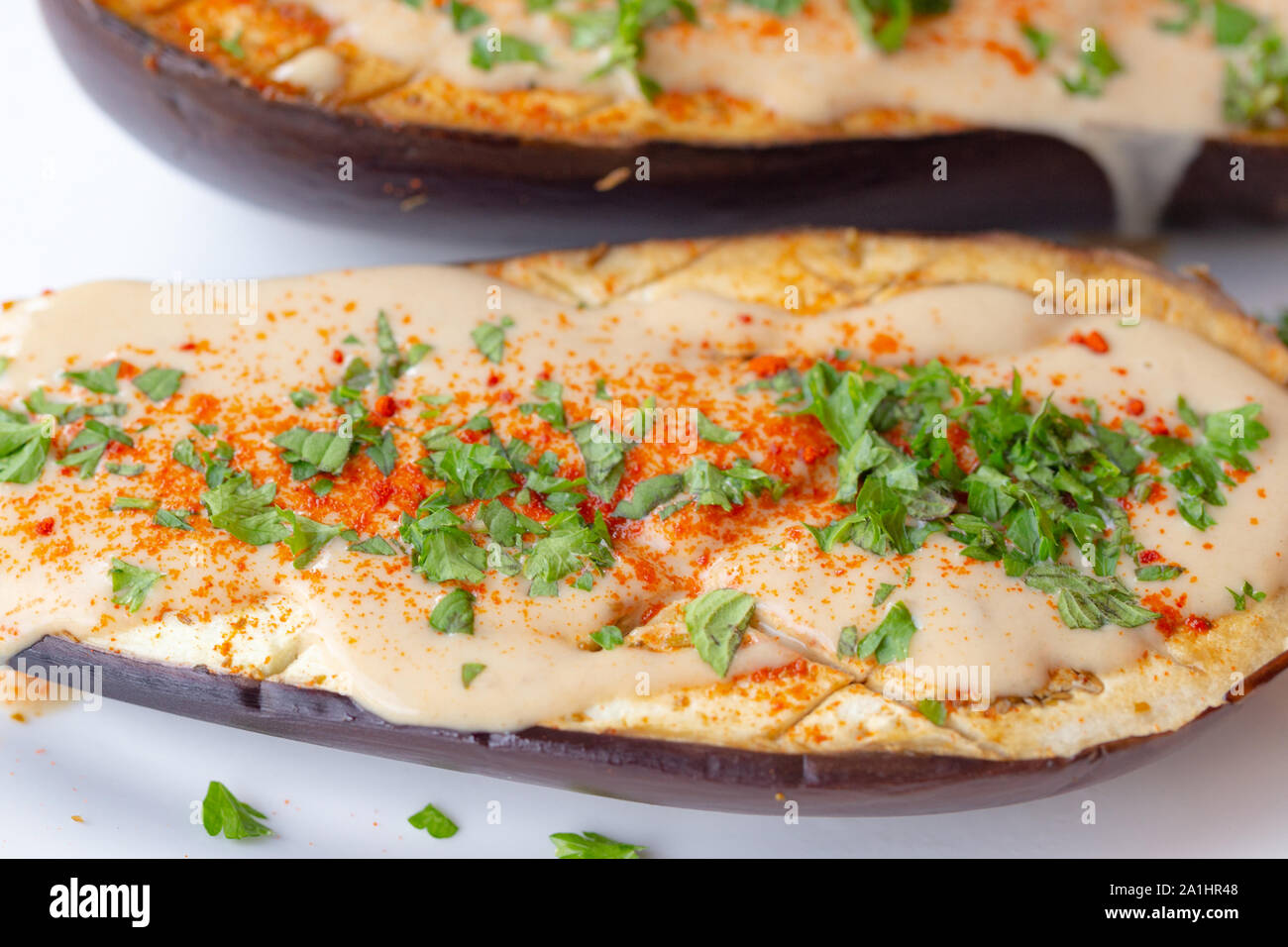 Oven roasted eggplant with vegan tahini sauce, ghost pepper powder and parsley Stock Photo Alamy