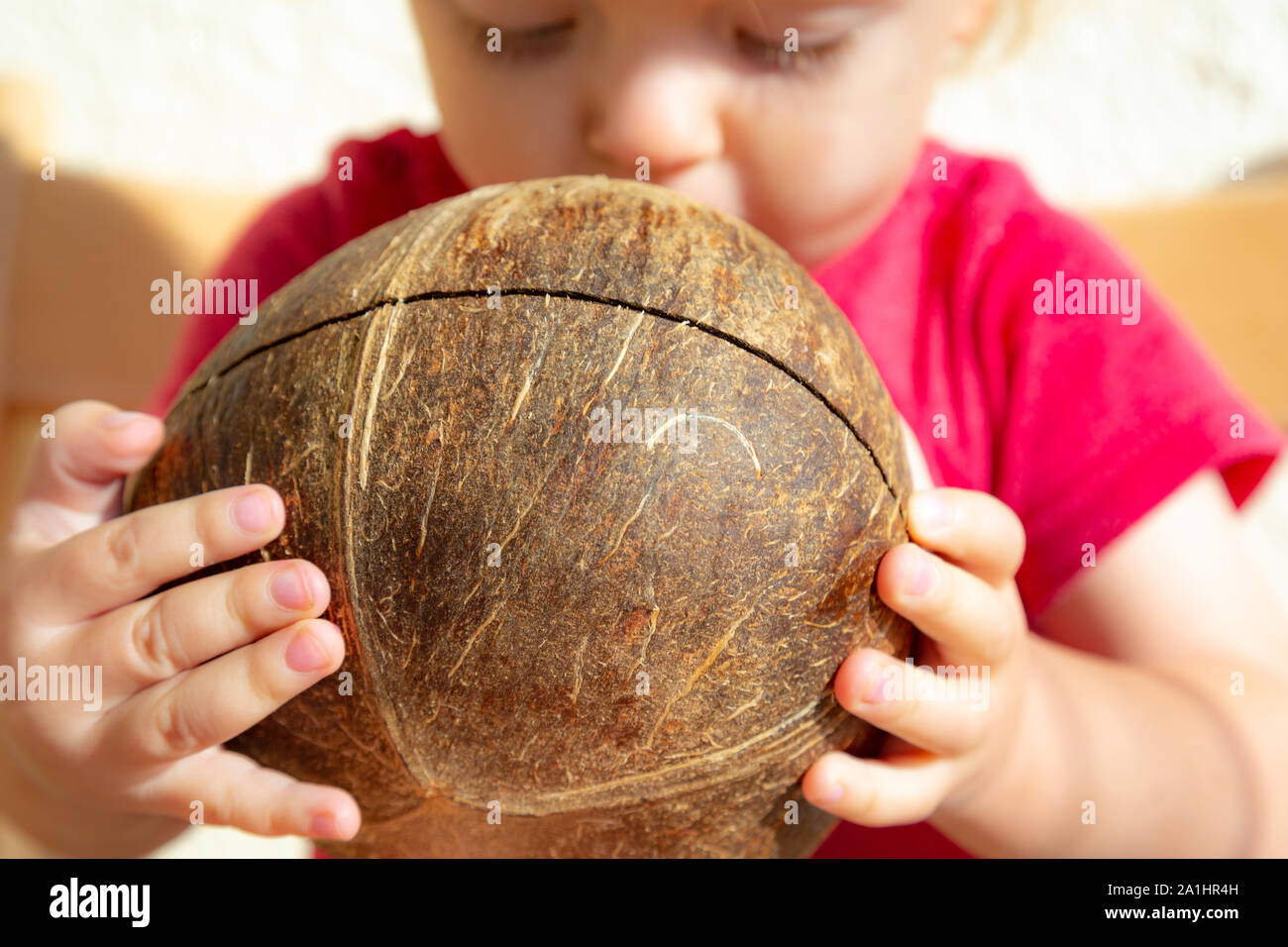 Young toodler is drinking fresh organic coconut water with a straw Stock Photo