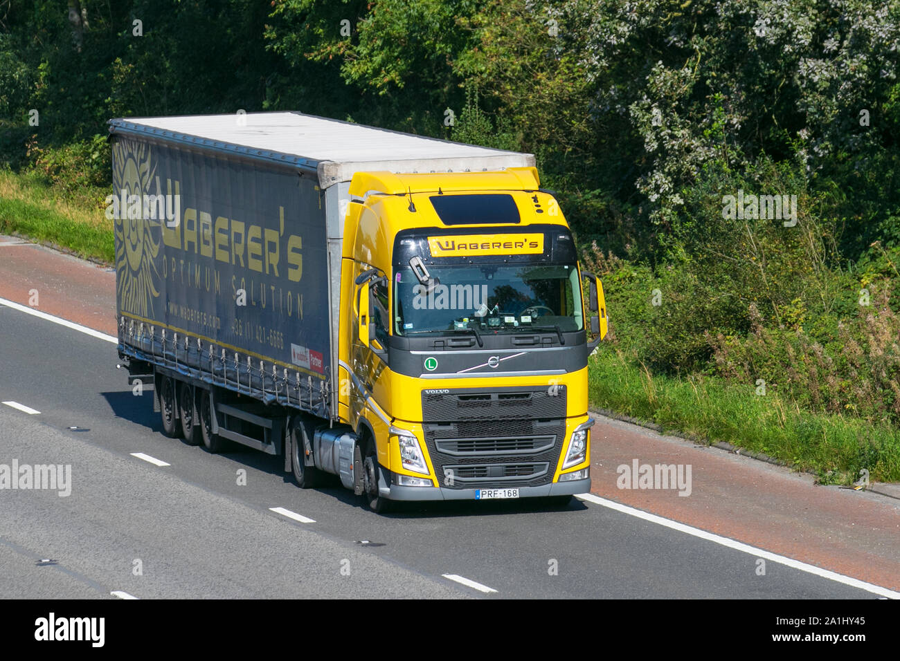 Waberers (Waberer's International Nyrt) Optimum Solution dry foods transport; Heavy bulk Haulage delivery trucks, haulage, lorry, transportation, truck, cargo, Volvo vehicle, delivery, transport, industry, supply chain freight, on the M6 at Lancaster, UK Stock Photo