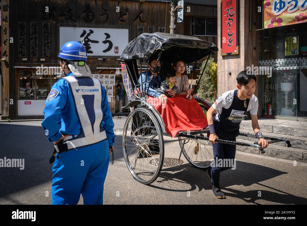 Tourists being drawn on a pulled rickshaw, Asakusa, Tokyo, Japan Stock Photo