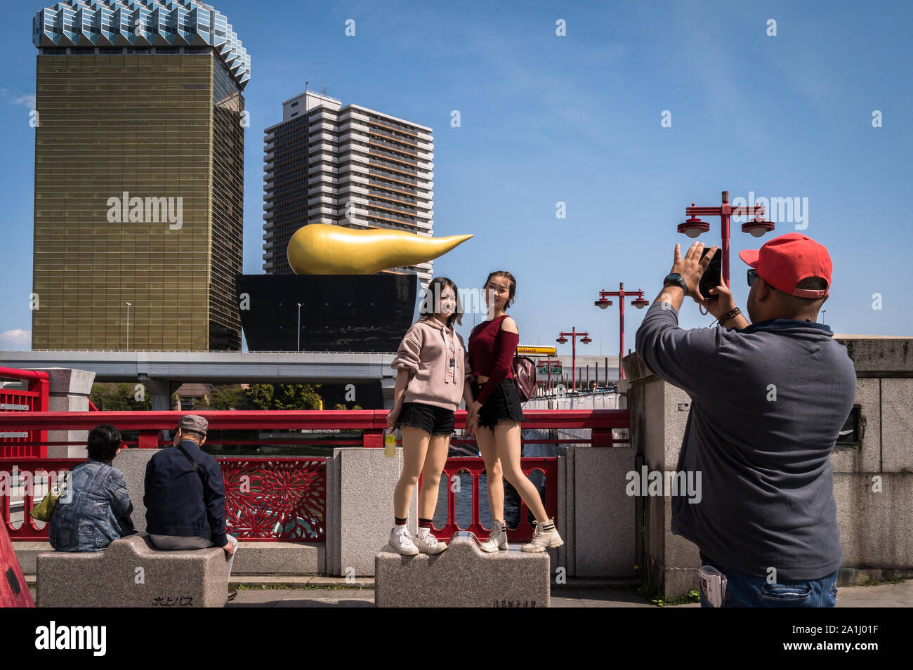 Tourists posing near Ueno Station with the Asahi Flame in the background, Tokyo, Japan. 18 April 2019 Stock Photo