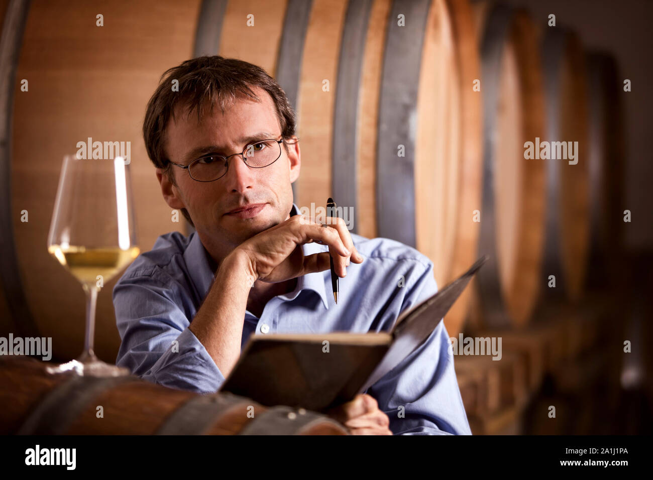 Wine producer contemplating in cellar. Stock Photo