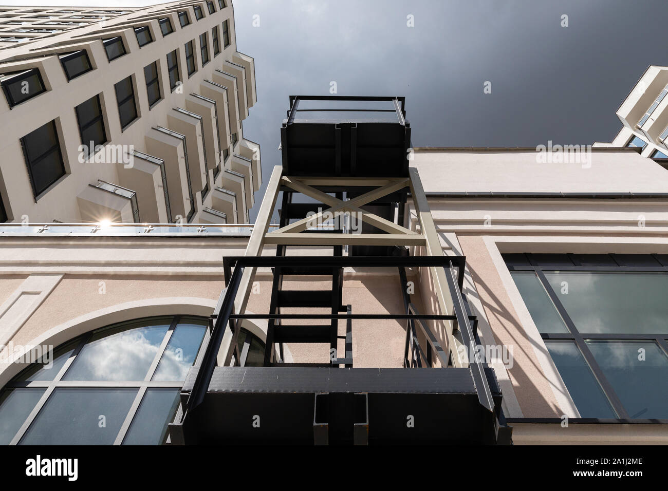 Bottom view of dark metal pompier ladder of luxury apartment building