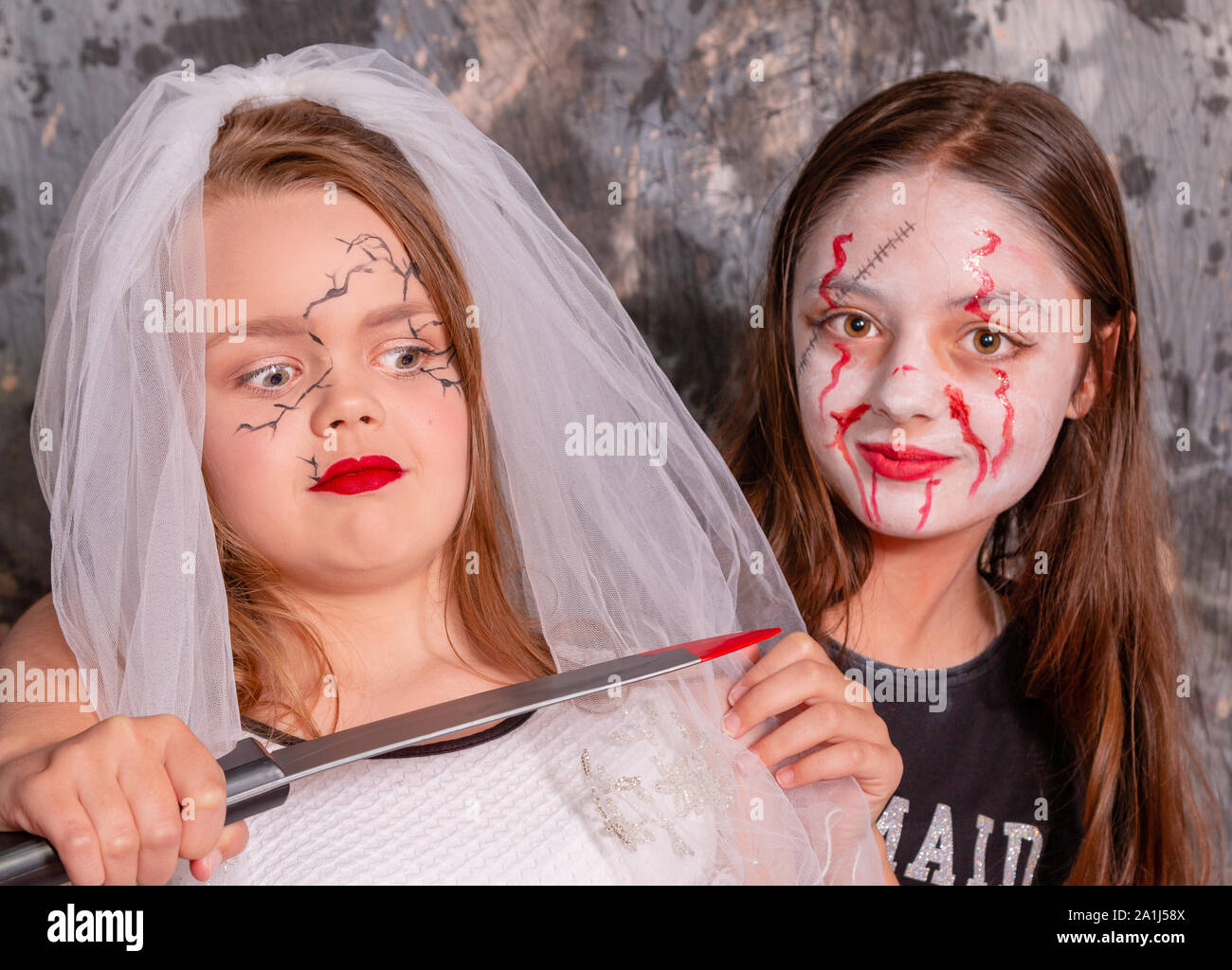 Young blood splattered female slits the throat of a bride  with a knife Stock Photo