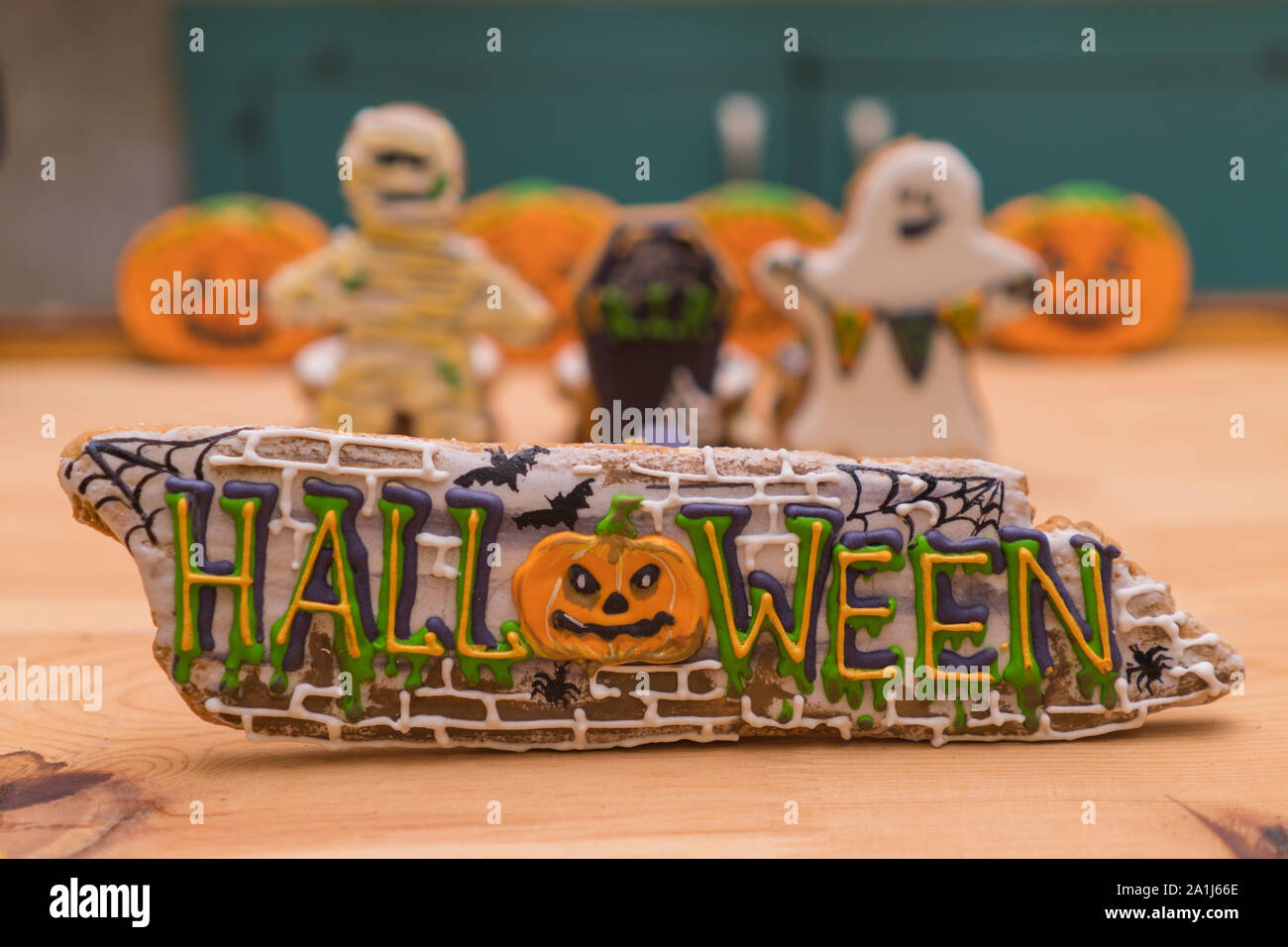 Halloween decals on gingerbreads and ghosts in the background in unfocus. Preparing for a Halloween party. Festive table Stock Photo