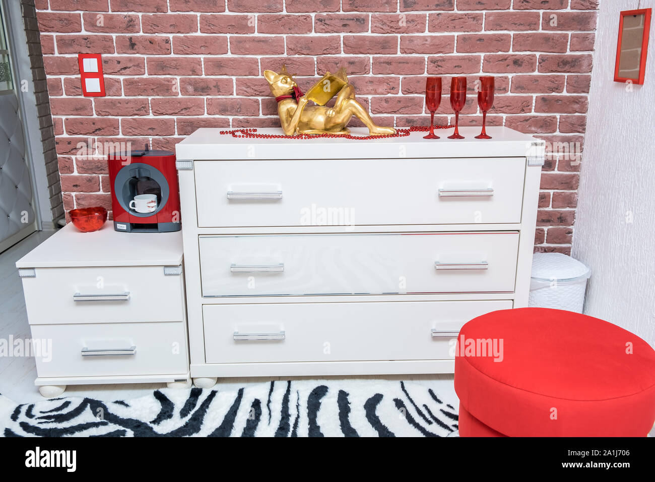A White Chest Of Drawers On A Background Of A Brick Orange