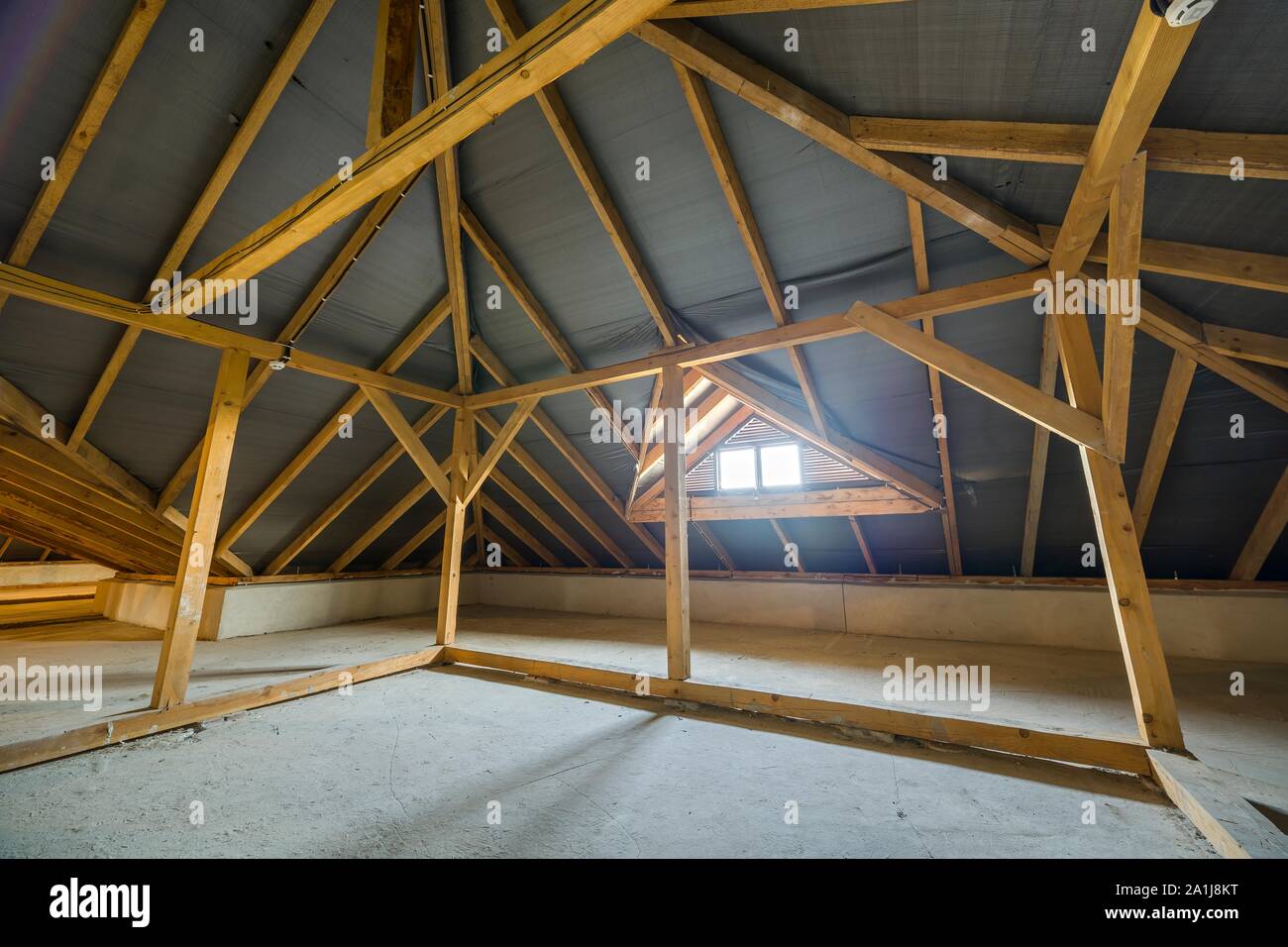 Attic of a building with wooden beams of a roof structure and a small ...