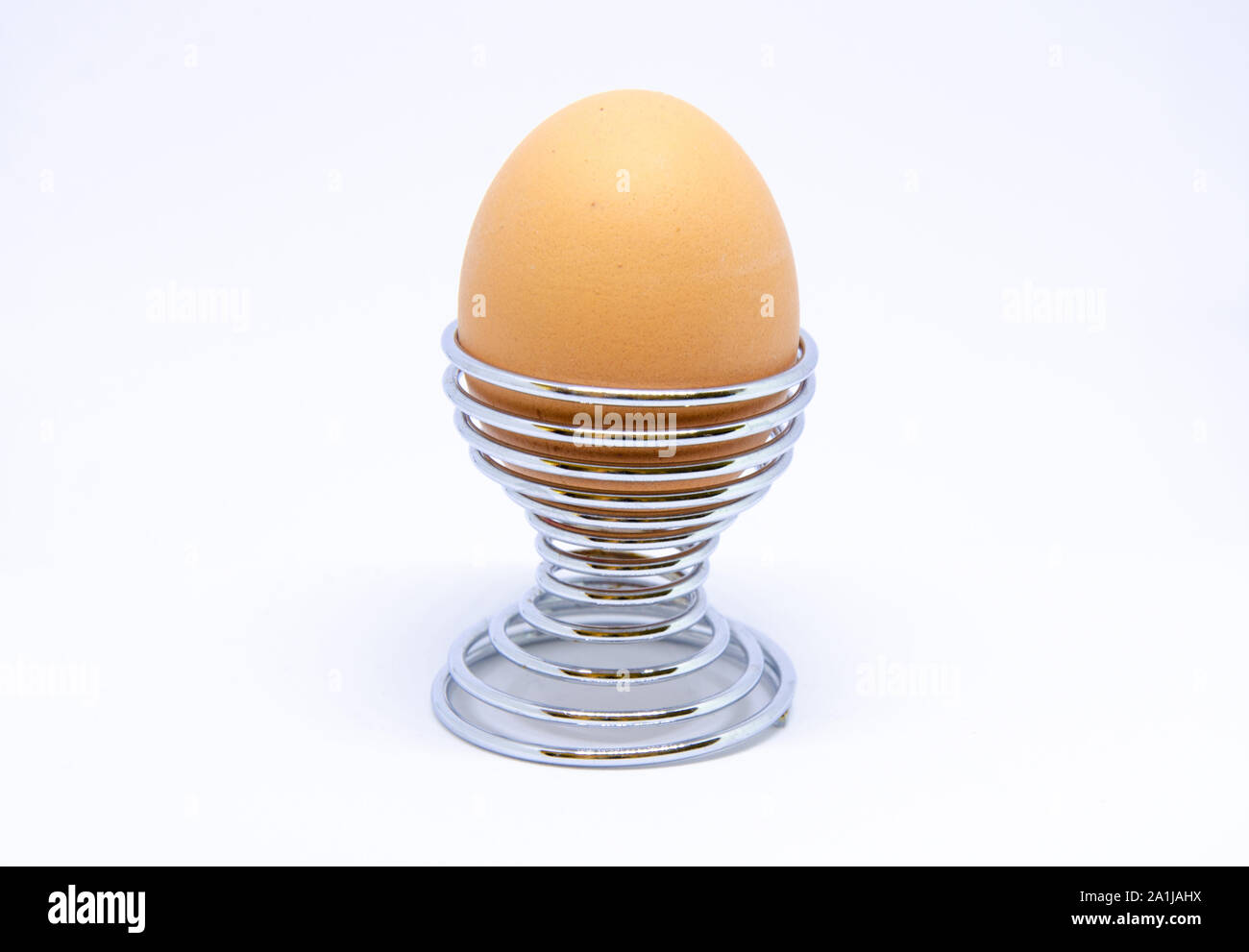 Boiled egg in an egg cup on a white background. Stock Photo