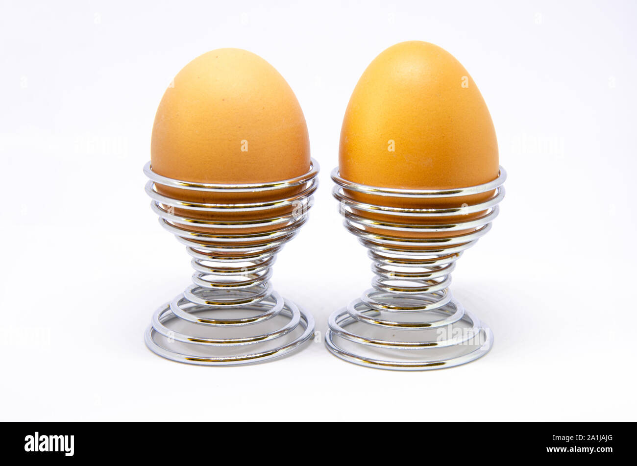 Boiled eggs in egg cups on a white background. Stock Photo