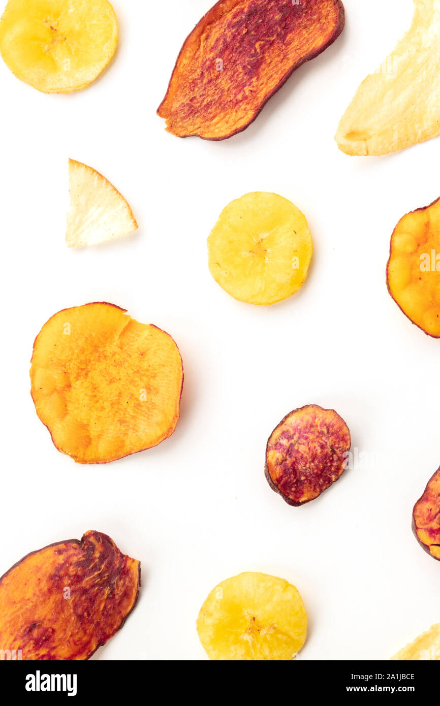 Dry fruit and vegetable chips, overhead shot. Healthy vegan snack, an organic food flat lay pattern on a white background Stock Photo