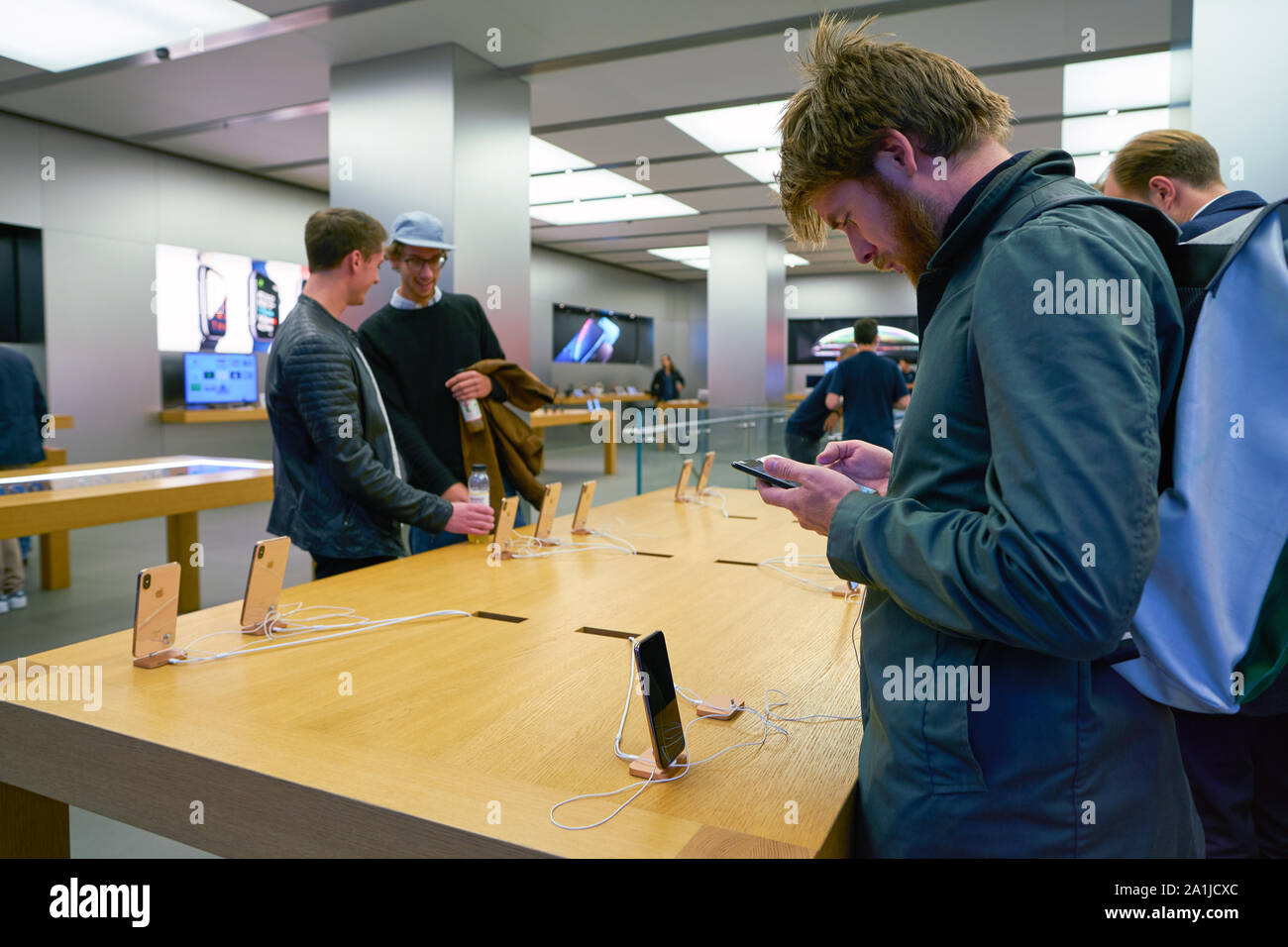 ZURICH, SWITZERLAND CIRCA OCTOBER, 2018 a man compare phones at the Apple store in Zurich