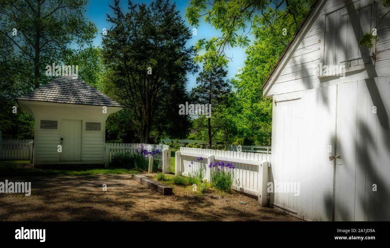 Garage, storage shed and white picket fence on a beautiful spring day Stock Photo