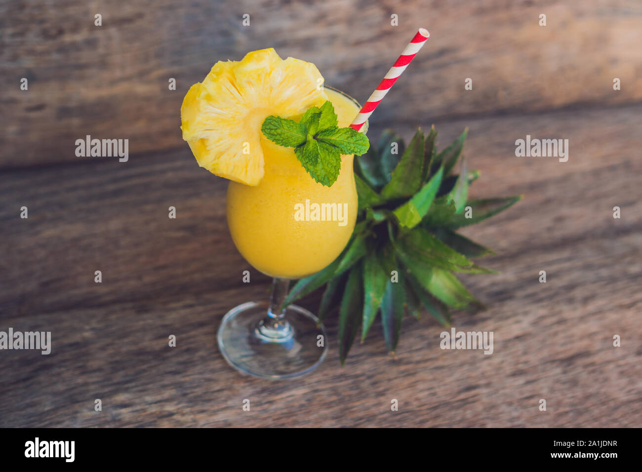 Pineapple and pineapple smoothies on an old wooden background. Stock Photo