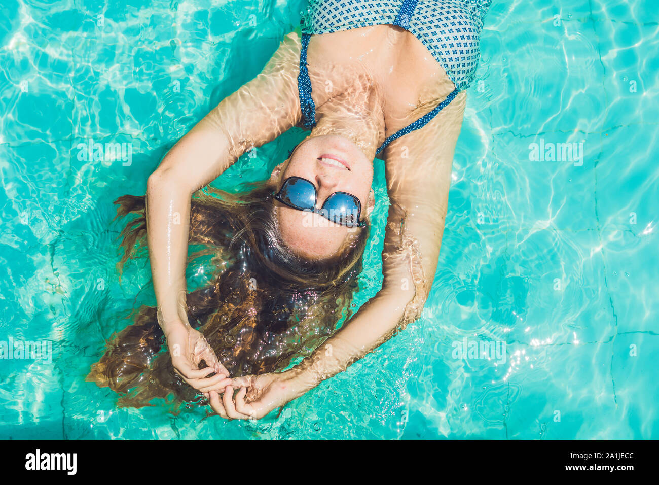 Beautiful young woman floating in pool relaxing Top view. Holiday ...