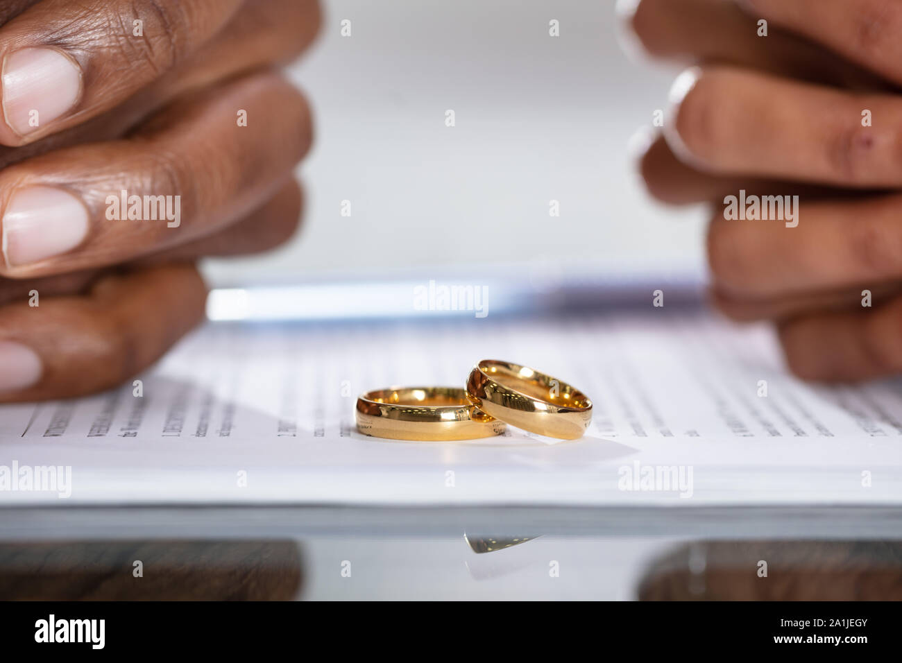 Couple Hands On Divorce Agreement Near Wedding Rings Stock Photo Alamy