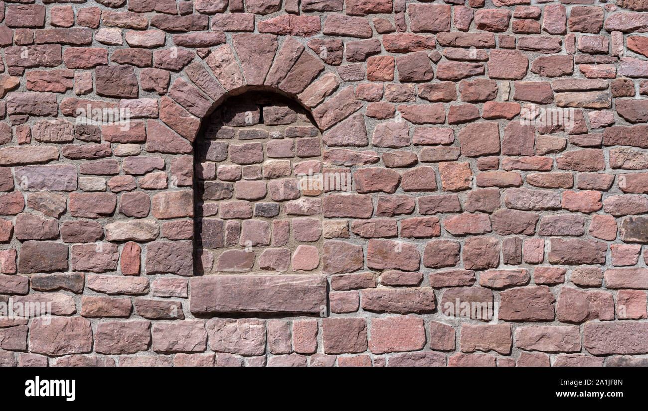 Reddish old wall with walled-up window Stock Photo