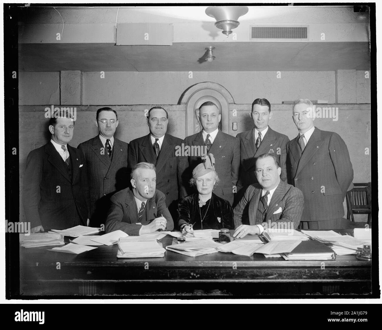 National Veteran's Employment Committee of the American Legion. Seated, L-R: Jack Crowley of Vermont, Nat'l Chairman of Vet. Emp. Comm.; Mrs. Ada Mucklestone of Ill., National Chairman of the American Legion Auxiliary; Paul H. Griffith, (D.C.), National Director of Re-Employment. Standing, L-R: [...], F. Regan of N.J.; Wm. D. Reilly of Kansas; Roy S. Stockton of California; Spencer Boise of North Dakota; James W. Hammond of Kentucky; Harold P. Redden of Massachusetts. Attending conferences at the Hamilton Hotel about securing employment for World War Veterans Stock Photo