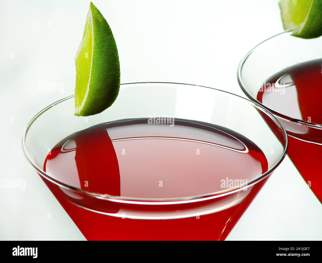 Bright red Bacardi alcoholic cocktail of white rum, lime juice and grenadine, in cocktail glasses decorated with lime slices, on a light background Stock Photo