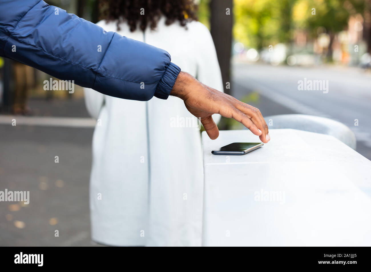 Person Picking Up Lost Phone On Street Stock Photo