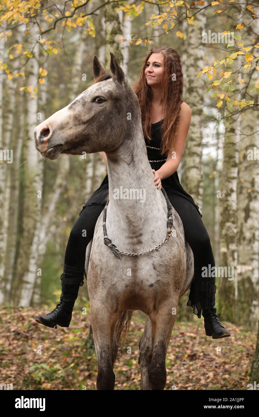 Amazing girl with long hair riding a horse without bridle Stock Photo -  Alamy
