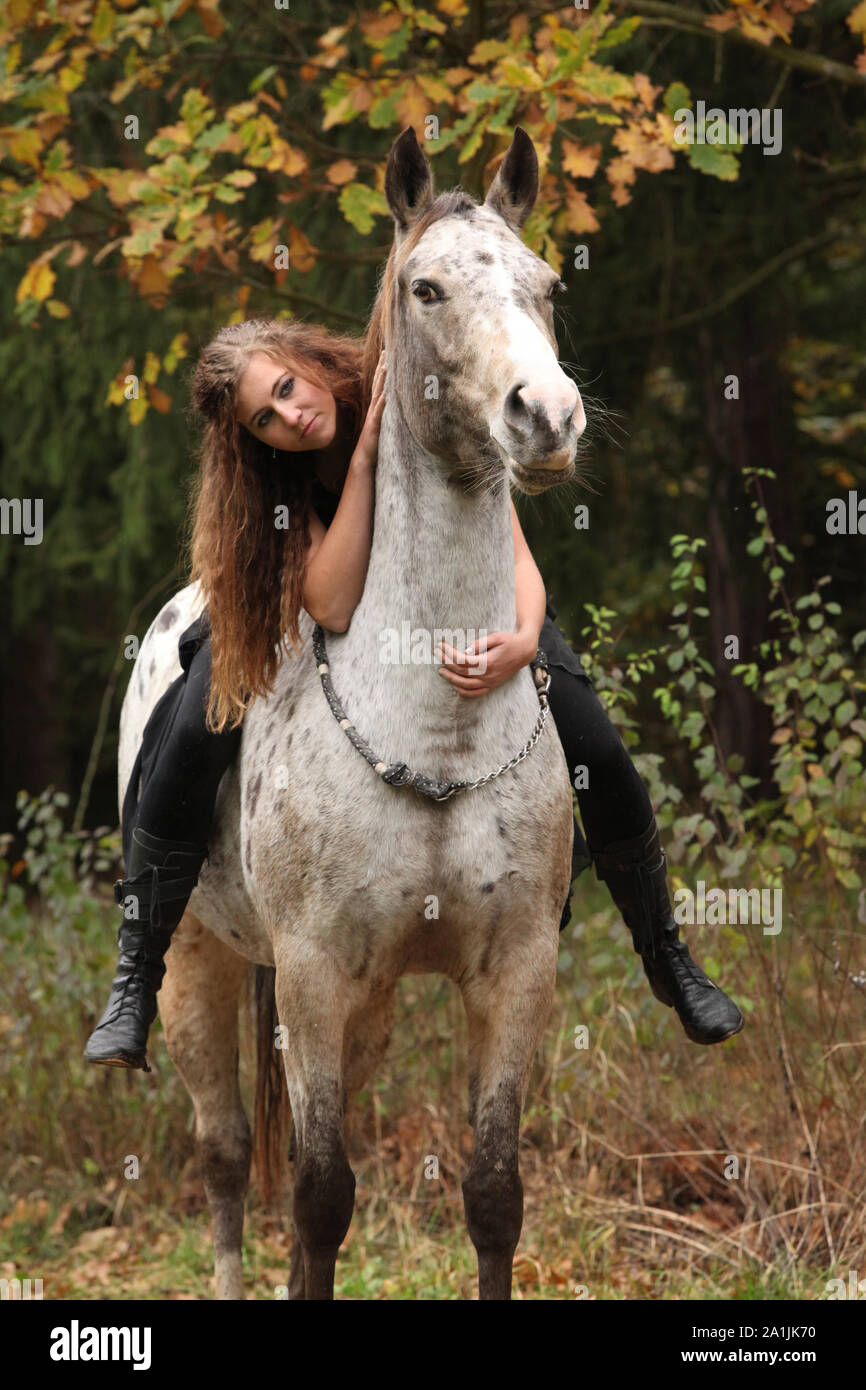 Beautiful girl riding a horse without bridle or saddle in autumn Stock