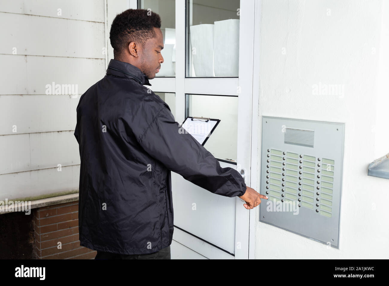 Man Standing In Front Of The House Knocking The Door Stock Photo