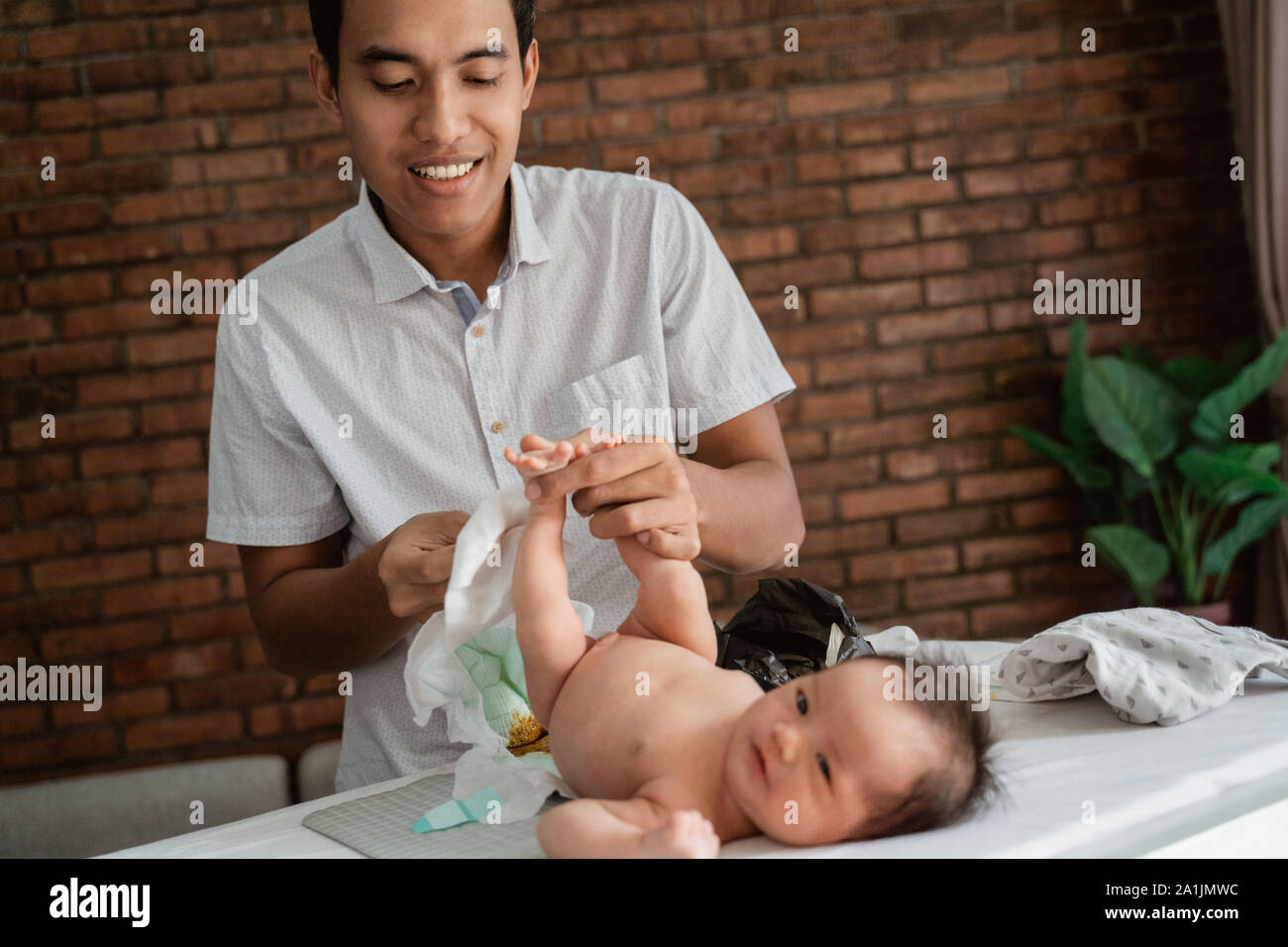 expression of father when change diapers for the baby's Stock Photo Alamy