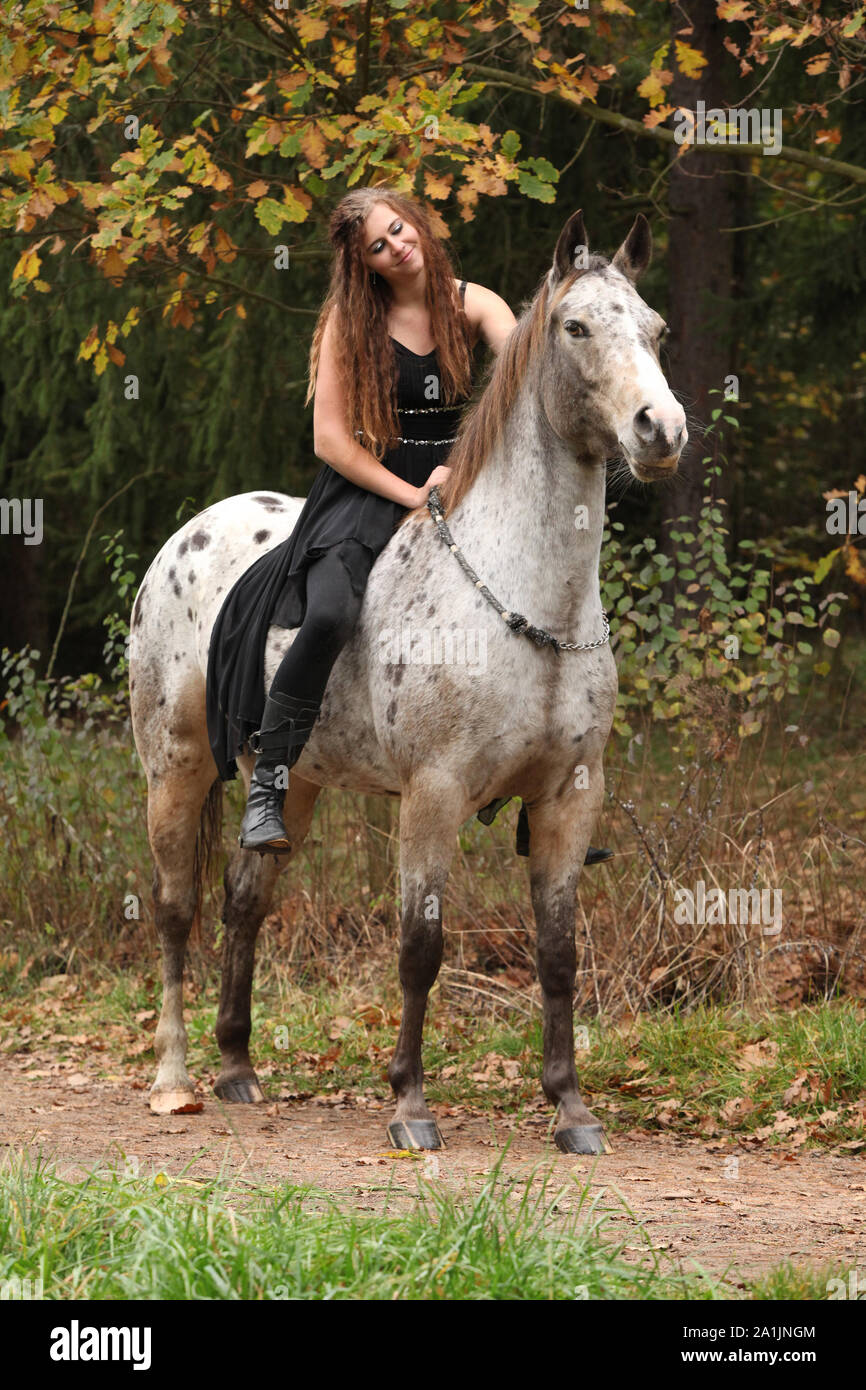 Beautiful girl riding a horse without bridle or saddle in autumn Stock