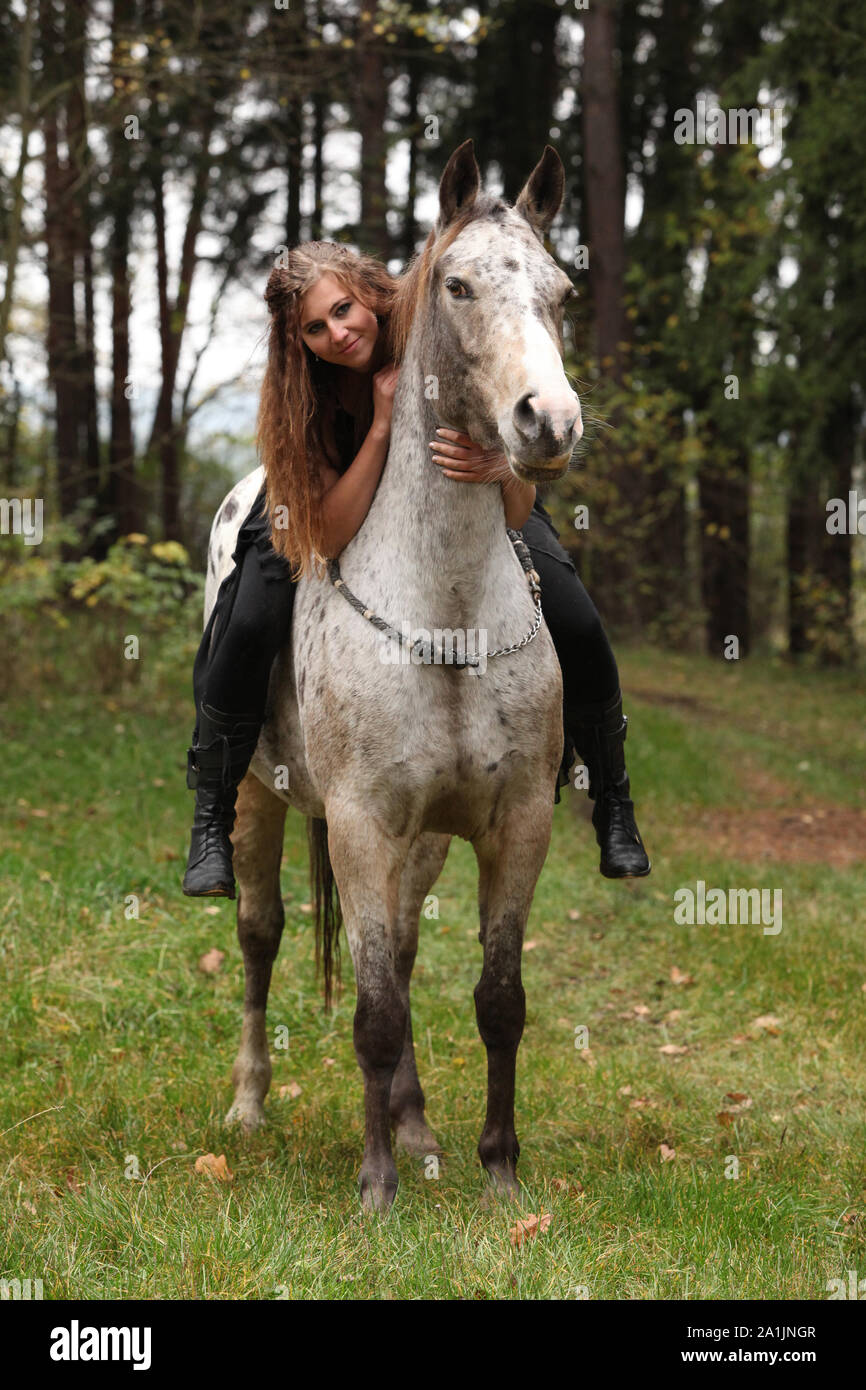 Beautiful girl riding a horse without bridle or saddle in autumn Stock