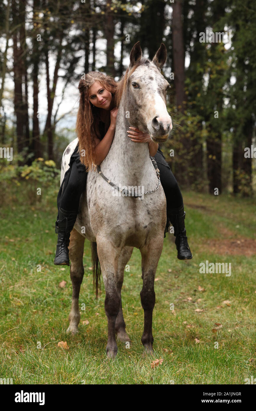Beautiful girl riding a horse without bridle or saddle in autumn Stock Photo