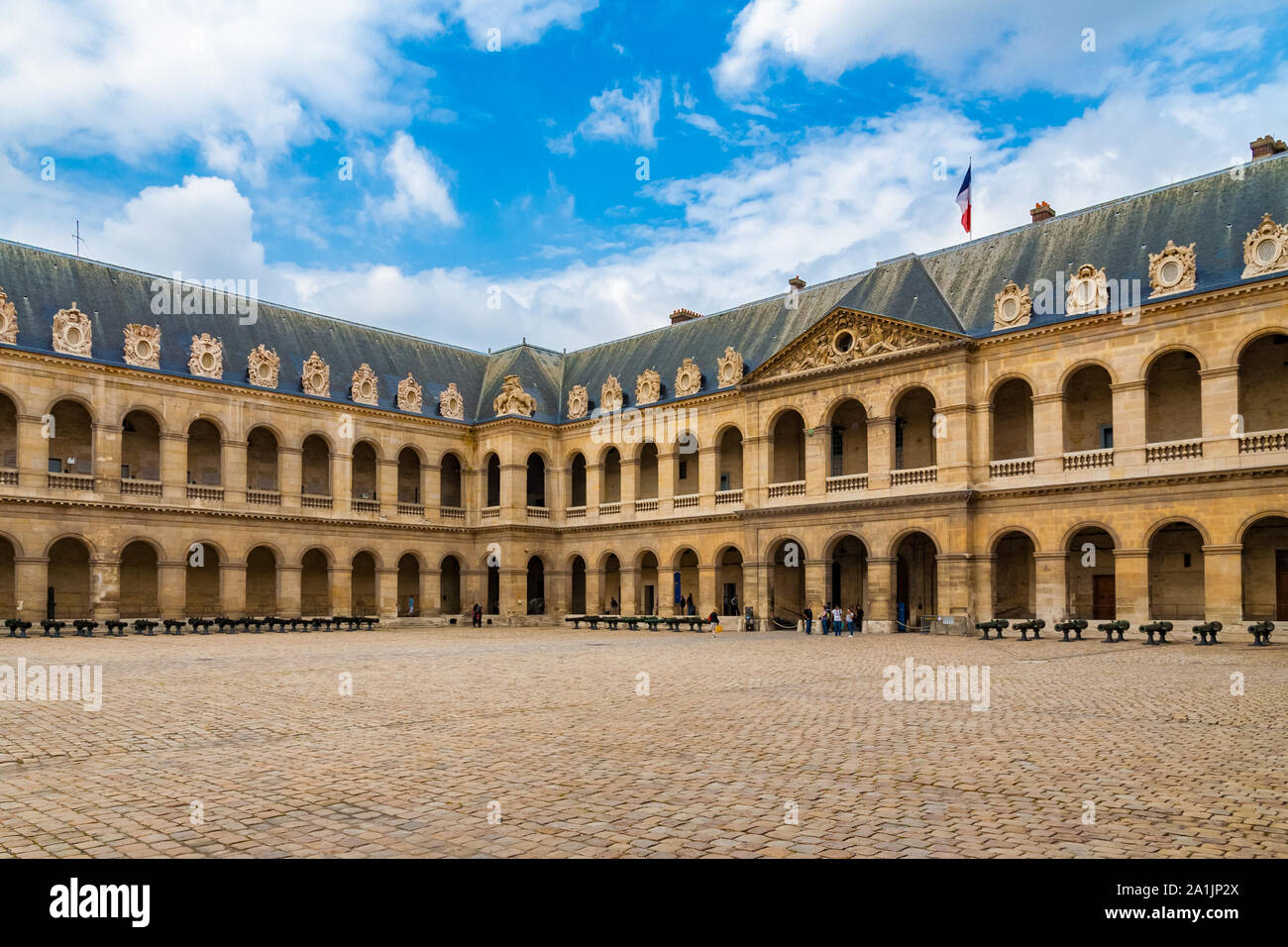 Panoramic view inside the cour d'honneur (court of honour) with rows of historic cannons. Built for military parades, it is the largest courtyard of... Stock Photo