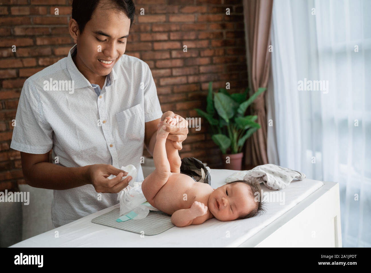 expression of father when change diapers for the baby's Stock Photo Alamy